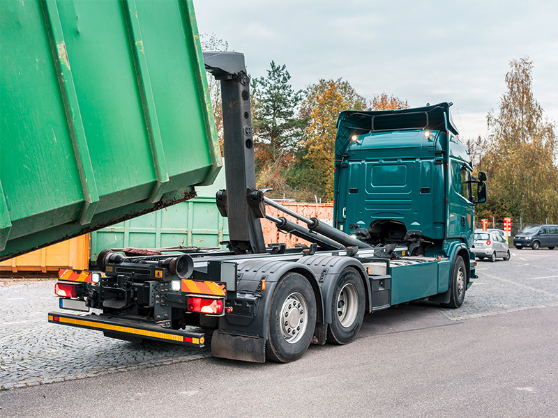 Lkw lädt grünen Container, zeigt effiziente Entsorgung und Containerdienst in Lüdenscheid.