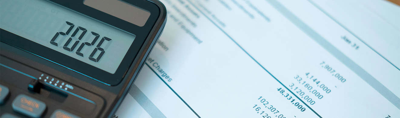 Taschenrechner mit Anzeige 2026 liegt auf Finanzberichten und Tabellen zur Planung des Jahresabschlusses in Lüdenscheid