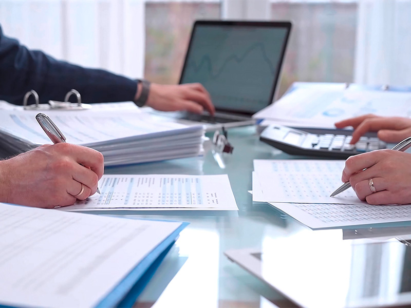 Zwei Fachkräfte prüfen Finanzunterlagen und berechnen Kennzahlen für den Jahresabschluss in Lüdenscheid im Büro