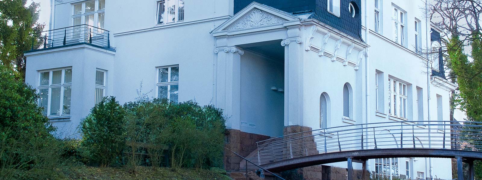 Außenansicht der Kanzlei Friebe – Prinz + Partner in Lüdenscheid, Firmengebäude mit Eingangsbereich und Kanzleischild.