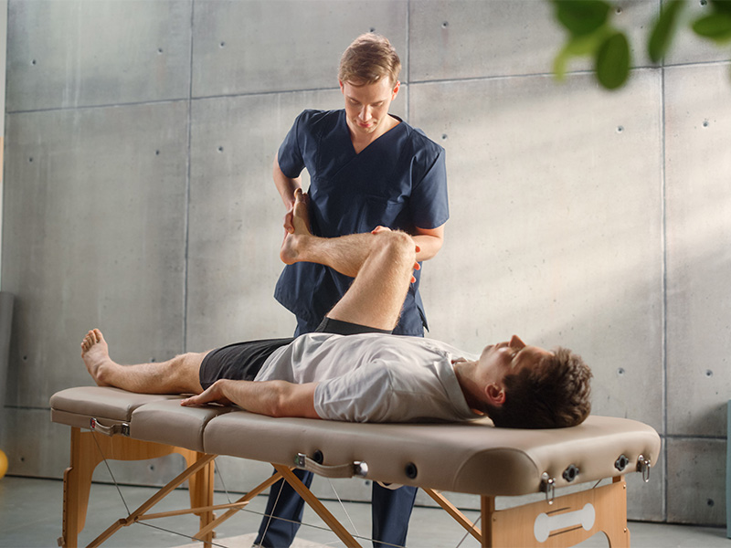 Physiotherapeut führt gezielte Krankengymnastik mit Athleten durch, um Beweglichkeit und Muskelkraft nach Verletzung wiederherzustellen.