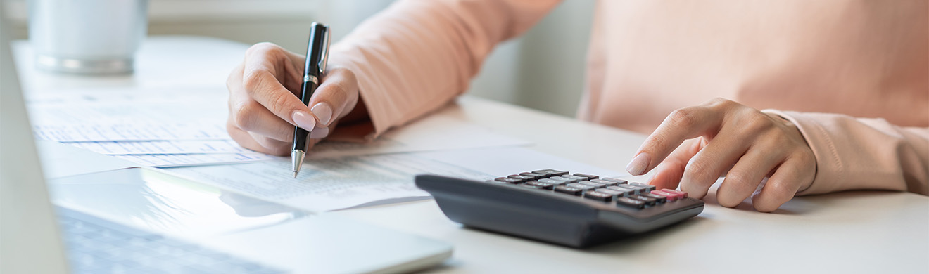 Frau prüft sorgfältig finanzielle Unterlagen – exemplarisch für die Arbeit eines Wirtschaftsprüfers in Lüdenscheid.